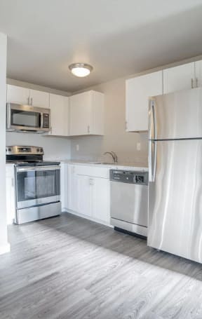 a kitchen with white cabinets and a sink and a window