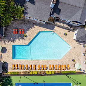 An aerial view of a swimming pool surrounded by orange chairs.
