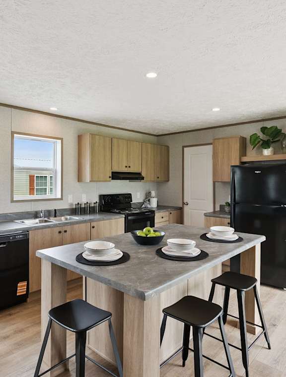 A kitchen with a black fridge, black bar stool and a black counter top.