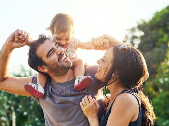 Mother and Father Smiling while Playing with Daughter
