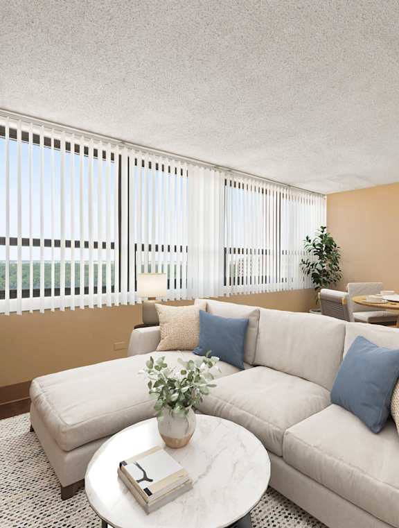 A living room with a white couch, a coffee table, and a dining table with chairs.