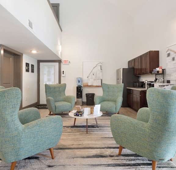 A large room with a blue couch and a chandelier. at Lakes Edge Apartments, Apartments, Greensboro, NC