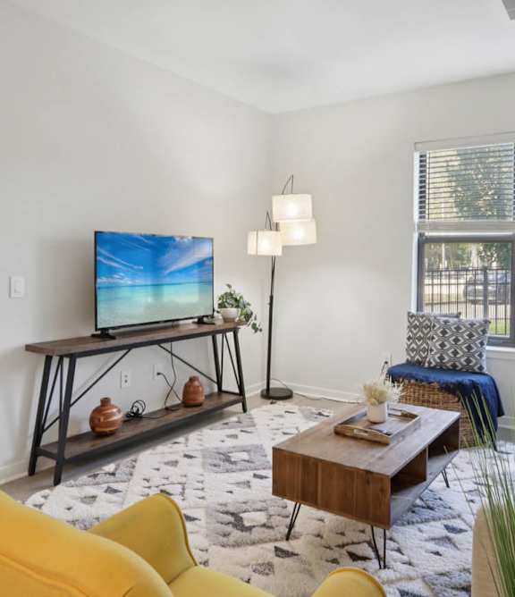 A living room with a yellow chair and a television.