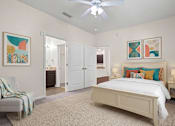 Thumbnail 5 of 28 - A bedroom with a bed, chair, and two pictures on the wall.
