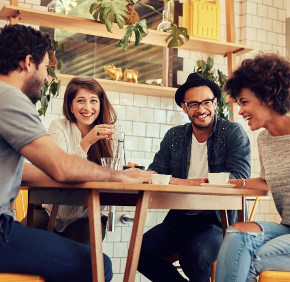 a group of people sitting around a table in a coffee shop
