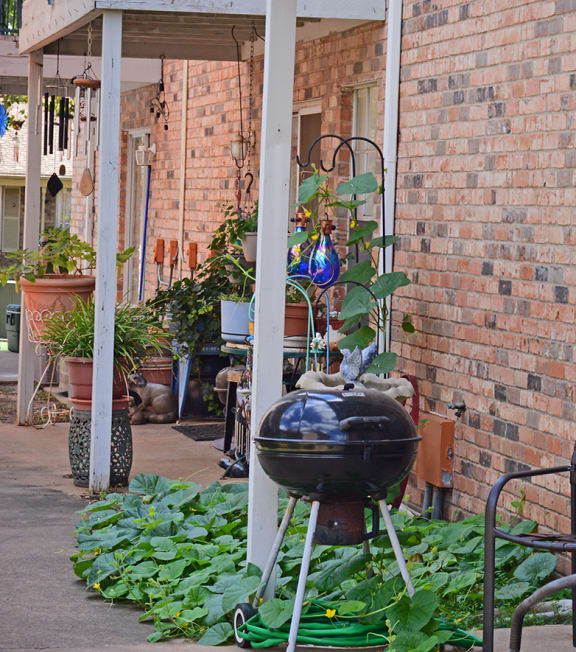 a grill on the porch of a brick building at Archer Village Apartments,Sherman, TX,