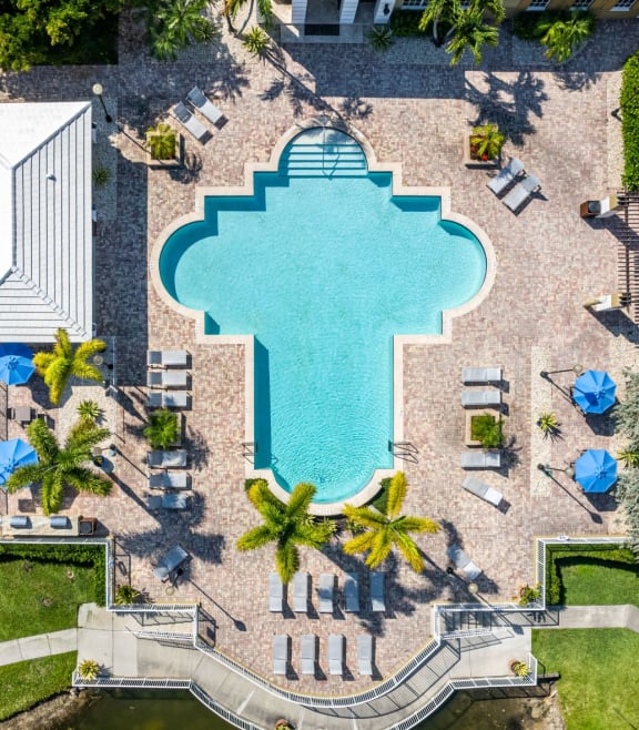 an aerial view of a resort style pool with chaise lounge chairs and palm trees at Promenade at Reflection Lakes, Fort Myers, 33907