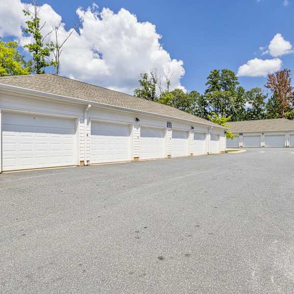A row of garages with trees in the background.