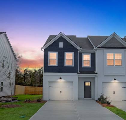 A row of houses with garages and driveways.