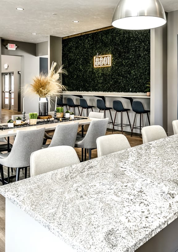 a clubhouse with a bar and a dining room with a table and chairs