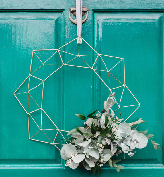 a hexagon shaped wreath on a green door