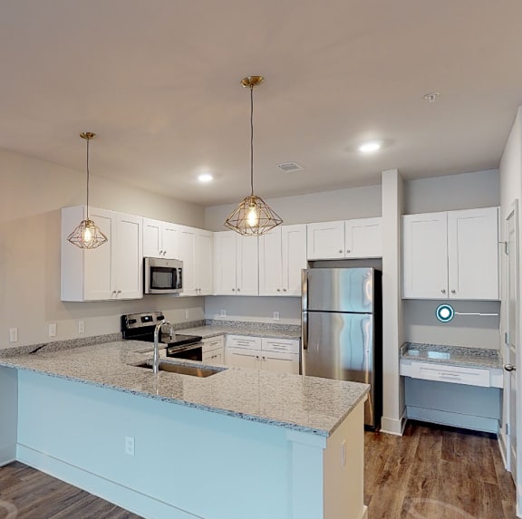 a kitchen with white cabinets and a counter top at Midtown Row, Montgomery
