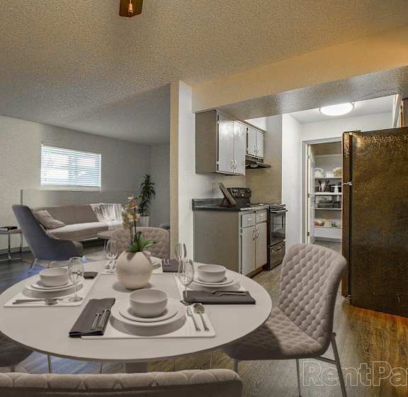 A dining room with a round table set for four.