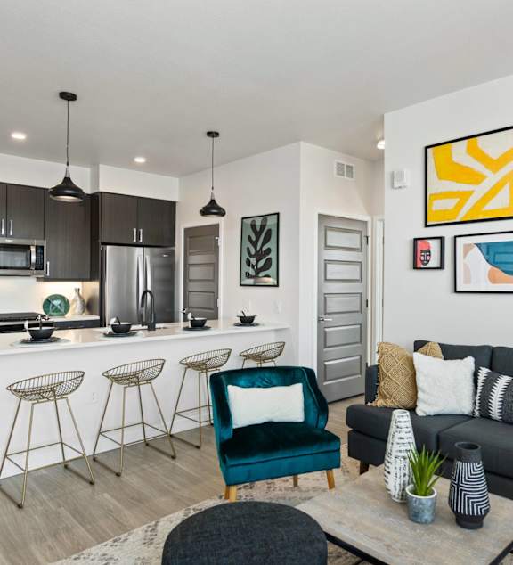 A modern kitchen with a bar and a living room with a couch.