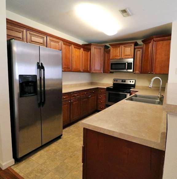 a kitchen with stainless steel appliances and wooden cabinets