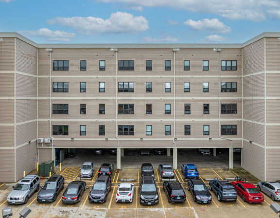 an apartment building with a parking lot full of cars