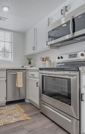 a kitchen with stainless steel appliances and white cabinets  at The Resort at Encinitas Luxury Apartment Homes, Encinitas, 92024