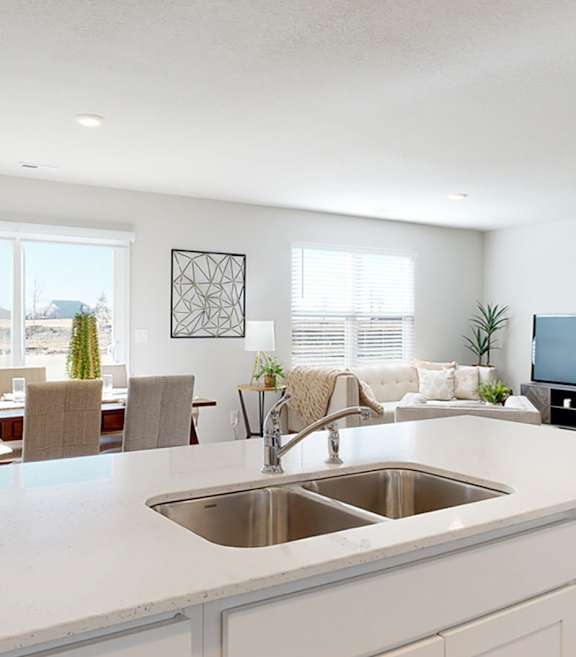 A modern kitchen with a large island and a dining table with chairs.