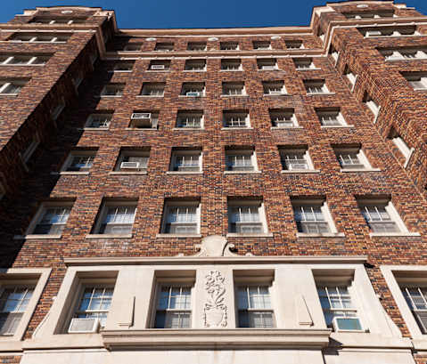 a tall brick building with a sign in front of it