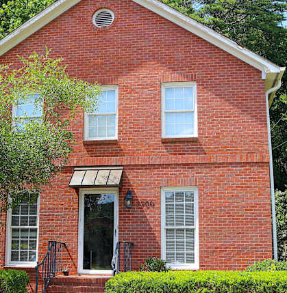 a red brick church with a tree in front of it
