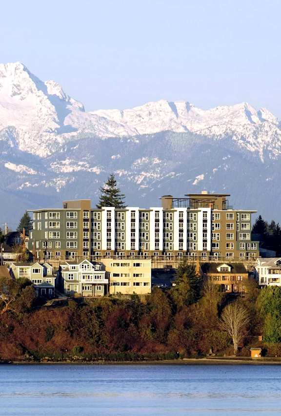A large building sits in front of a snowy mountain range.
