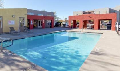 A swimming pool in a sunny outdoor setting.