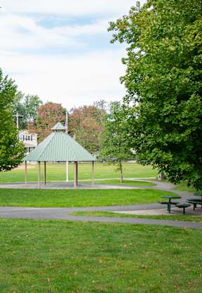 A park with a gazebo and picnic tables.