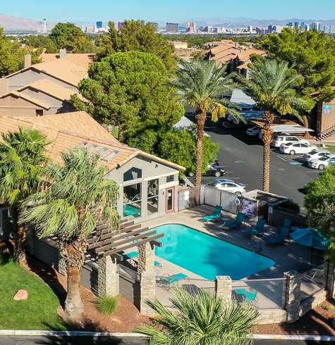 an aerial view of a house with a pool and palm trees