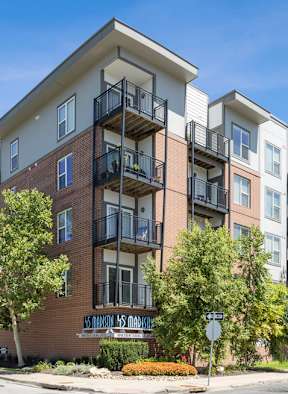 A street view of a residential building with a clear blue sky.
