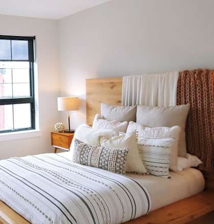 A room with a window and a hanging plant.