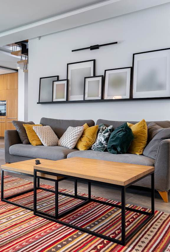 A living room with a grey couch and a wooden coffee table.