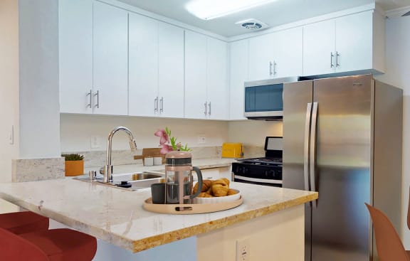 a kitchen with a breakfast bar and a stainless steel refrigerator  at Casa Granada, California, 90049