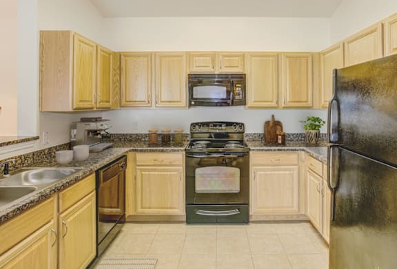 a kitchen with wood cabinets and black appliances