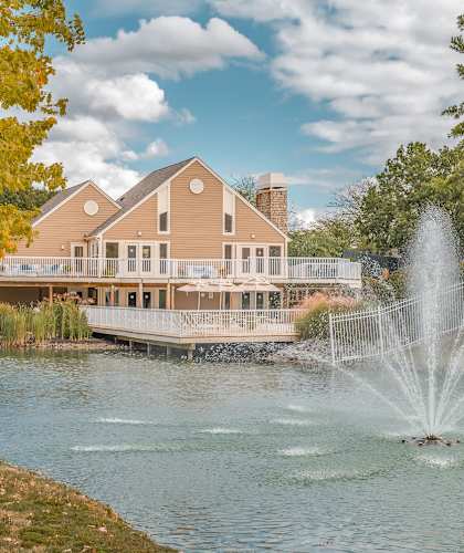 A house with a fountain in front of it.