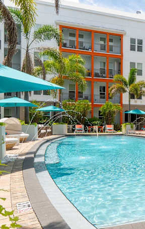 A pool surrounded by chairs and umbrellas.