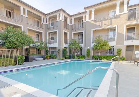 A swimming pool in front of apartment buildings.