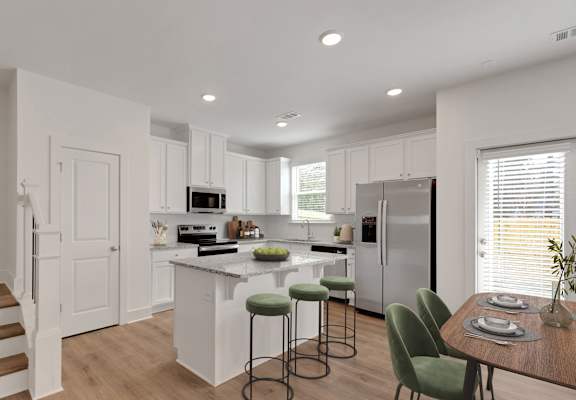 A kitchen with white cabinets and a white fridge.
