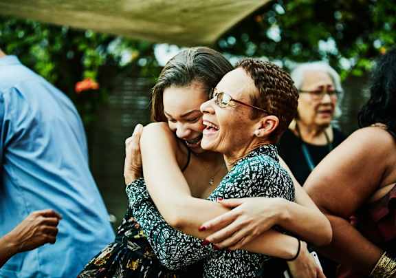 Two women hug each other in a celebratory moment.