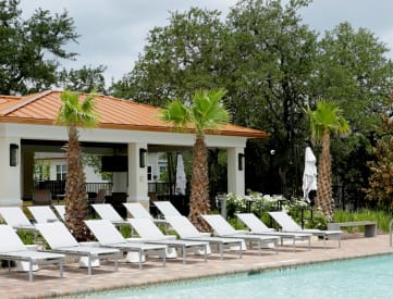 a pool with chaise lounge chairs and a gazebo