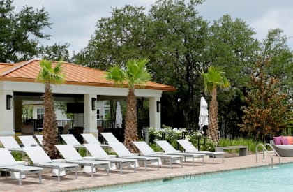 a pool with chaise lounge chairs and a gazebo