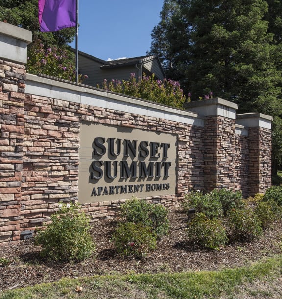 Sunset Summit apartments property entrance monument sign and flag  