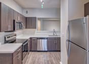 Thumbnail 8 of 30 - Kitchen with Stainless Steel Appliances at Stonelake at the Arboretum, Austin, TX, 78759