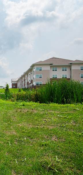 A sign for Lofisal Evergreen Estates stands in front of a grassy area.