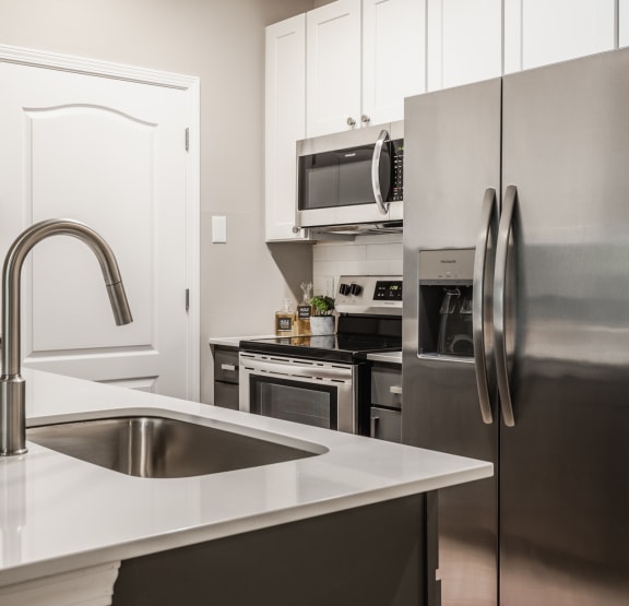 Luxury kitchen with stainless appliances and a sink at Alexandria of Carmel Apartments, Carmel, IN