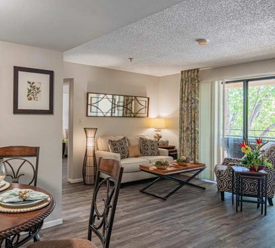 the view of a living room and kitchen with a dining room table and chairs