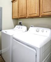 Two white washing machines in a laundry room.