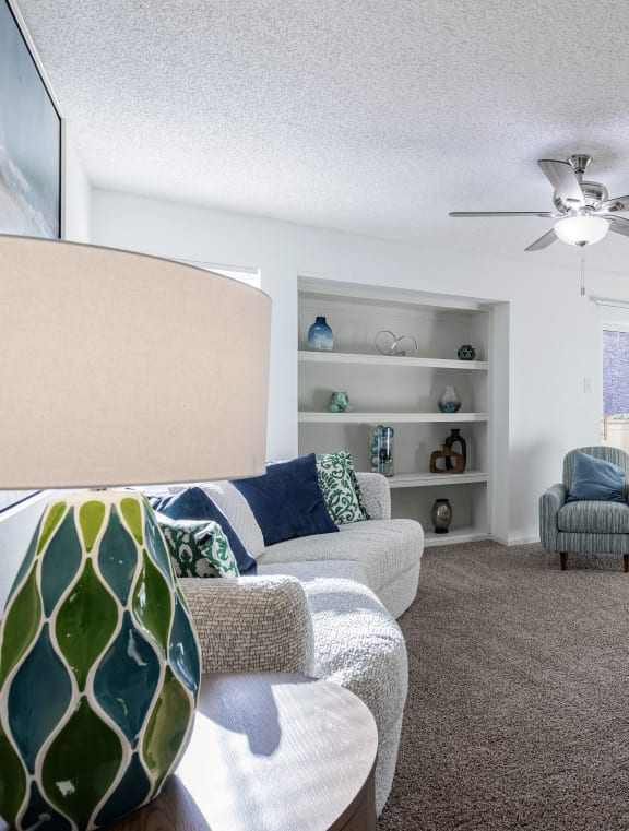  A cozy living space in the Skyler Ridge Apartments model unit with a couch and ceiling fan.