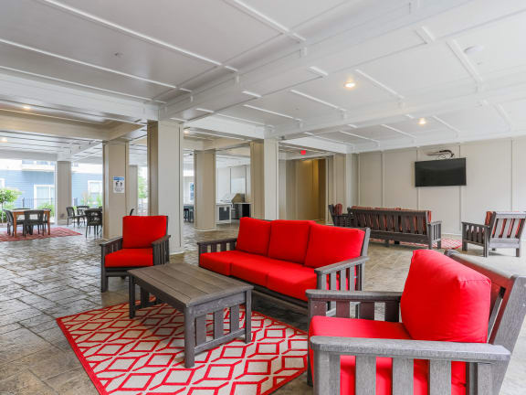 a living room with red couches and chairs and a table