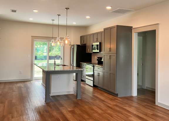A modern kitchen with wooden floors and stainless steel appliances at Allier Foley, Alabama