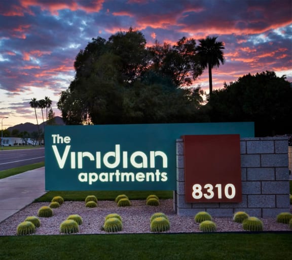 Sign for The Viridian Apartments at Dusk with Manicured Landscaping at The Viridian Apartments in Scottsdale, 85250